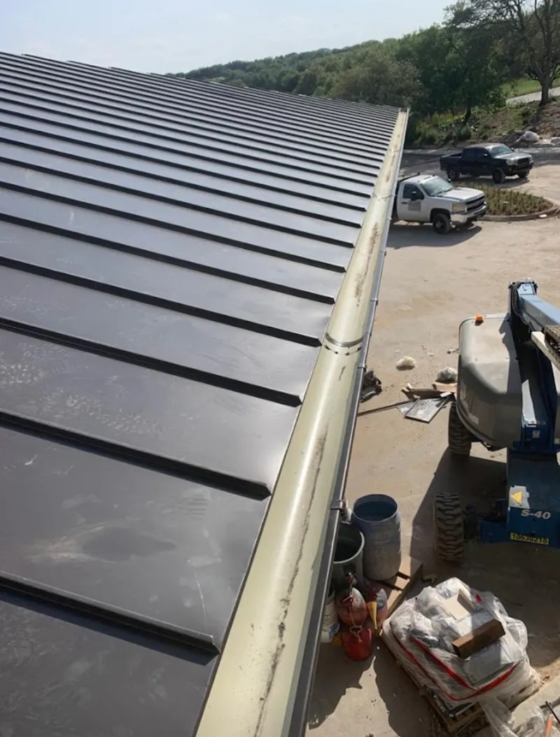 Standing seam panel and gutter detail on a metal roofing jobsite in Midwest City
